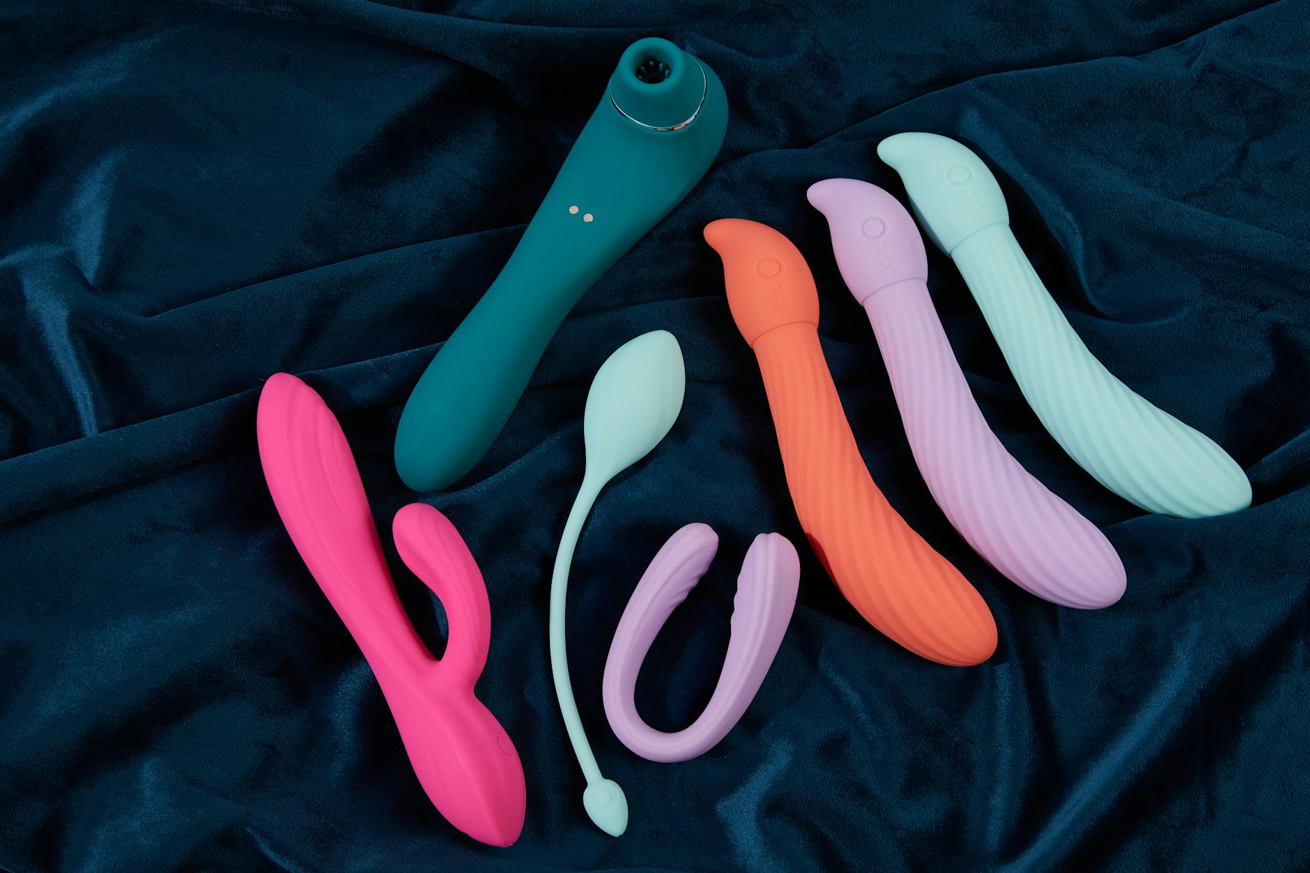 Mão segurando um vibrador moderno contra fundo minimalista roxo