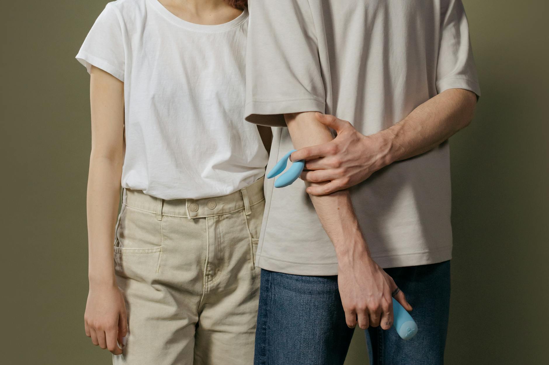 Casal jovem segurando um vibrador moderno, simbolizando intimidade contemporânea e exploração conjunta do prazer