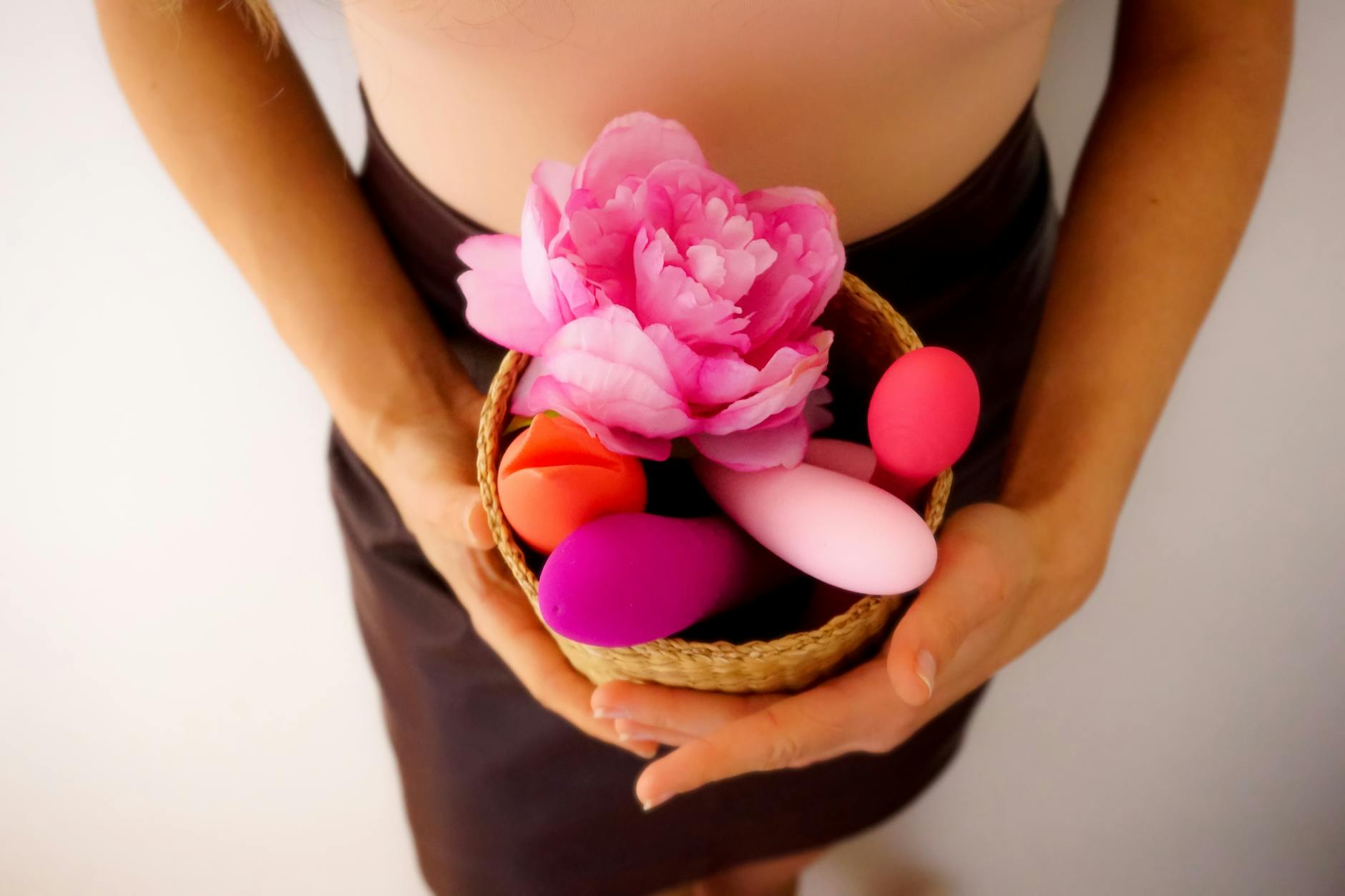 Mulher segurando um vibrador de silicone contra fundo roxo
